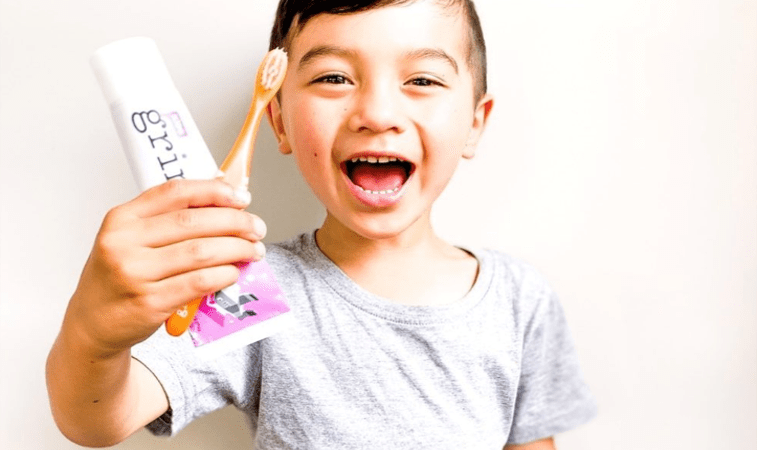 Little Boy Holding Grin Toothpaste & Toothbrush
